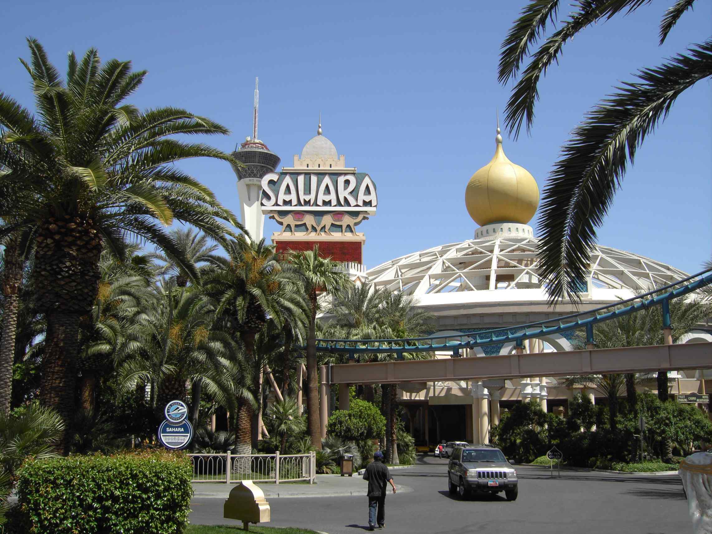 Sahara sign, palms, domed entrance and roller-coaster track in a historical exterior photograph.