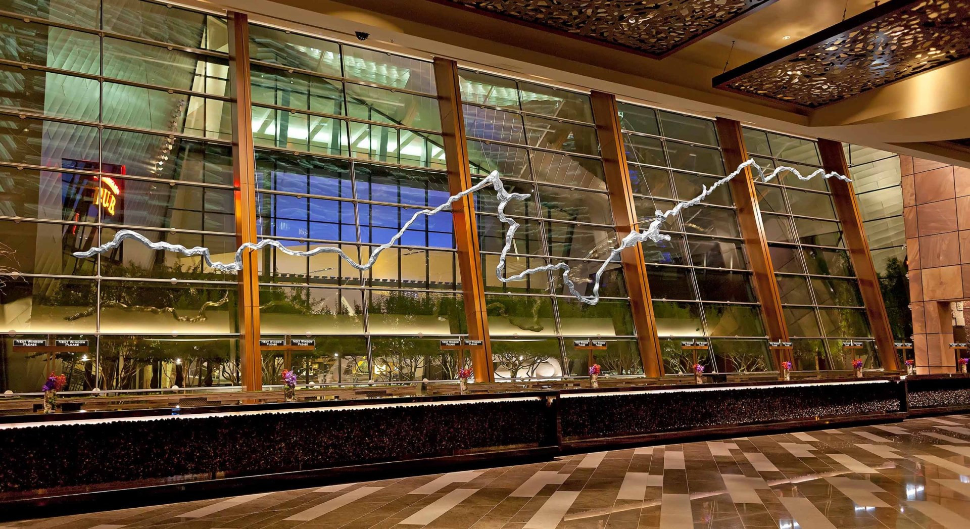 The suspended Silver River sculpture across the ARIA lobby windows.