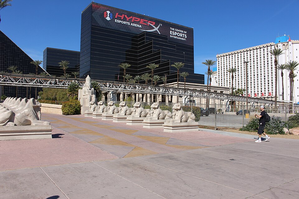 Luxor pyramid and Sphinx plaza in daylight, with a sports arena advertisement on the black facade.