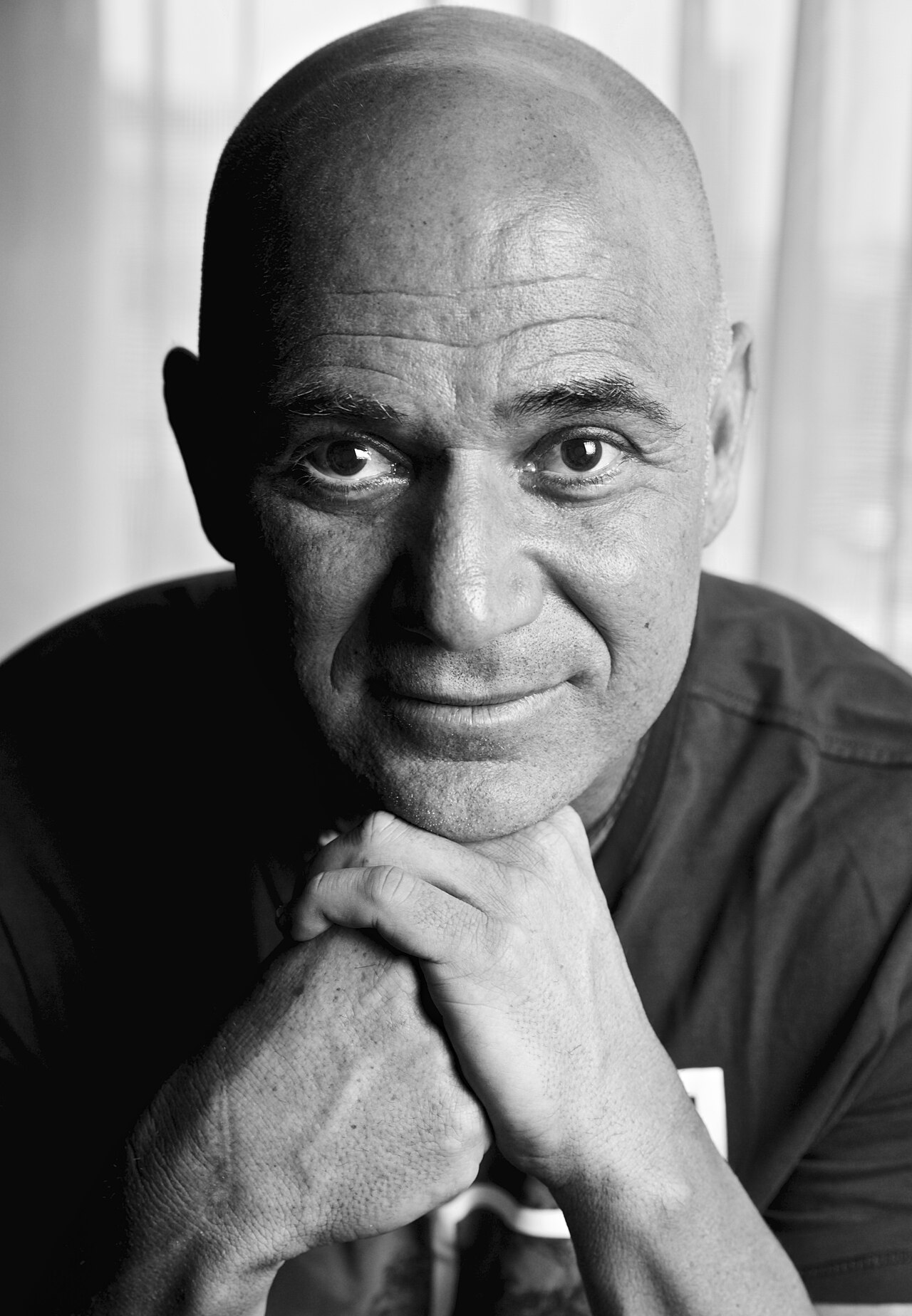 Black-and-white portrait of Andre Agassi resting his chin on his hand.