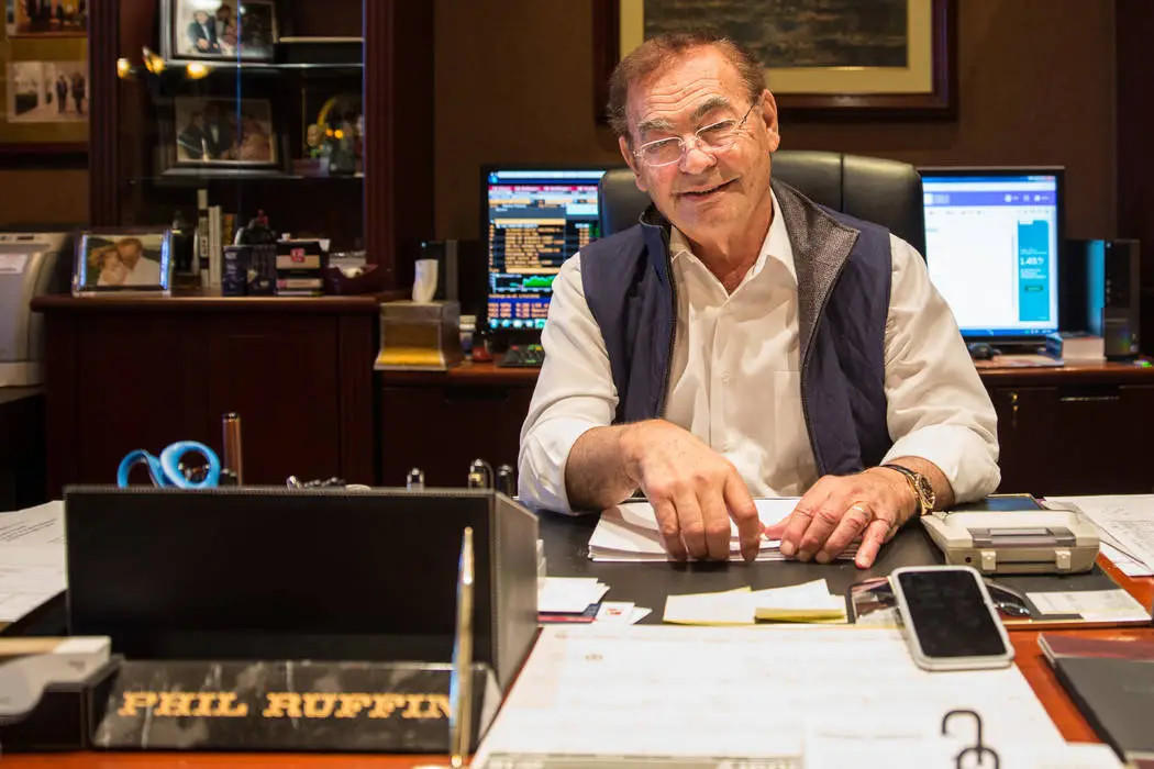 Phil Ruffin seated at a desk, with his nameplate in the foreground.