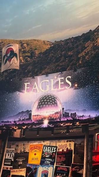 An Eagles display featuring Sphere artwork and a wall of concert posters.