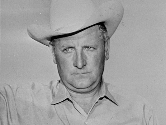 Black-and-white portrait of Ralph Lamb wearing a light cowboy hat and collared shirt.