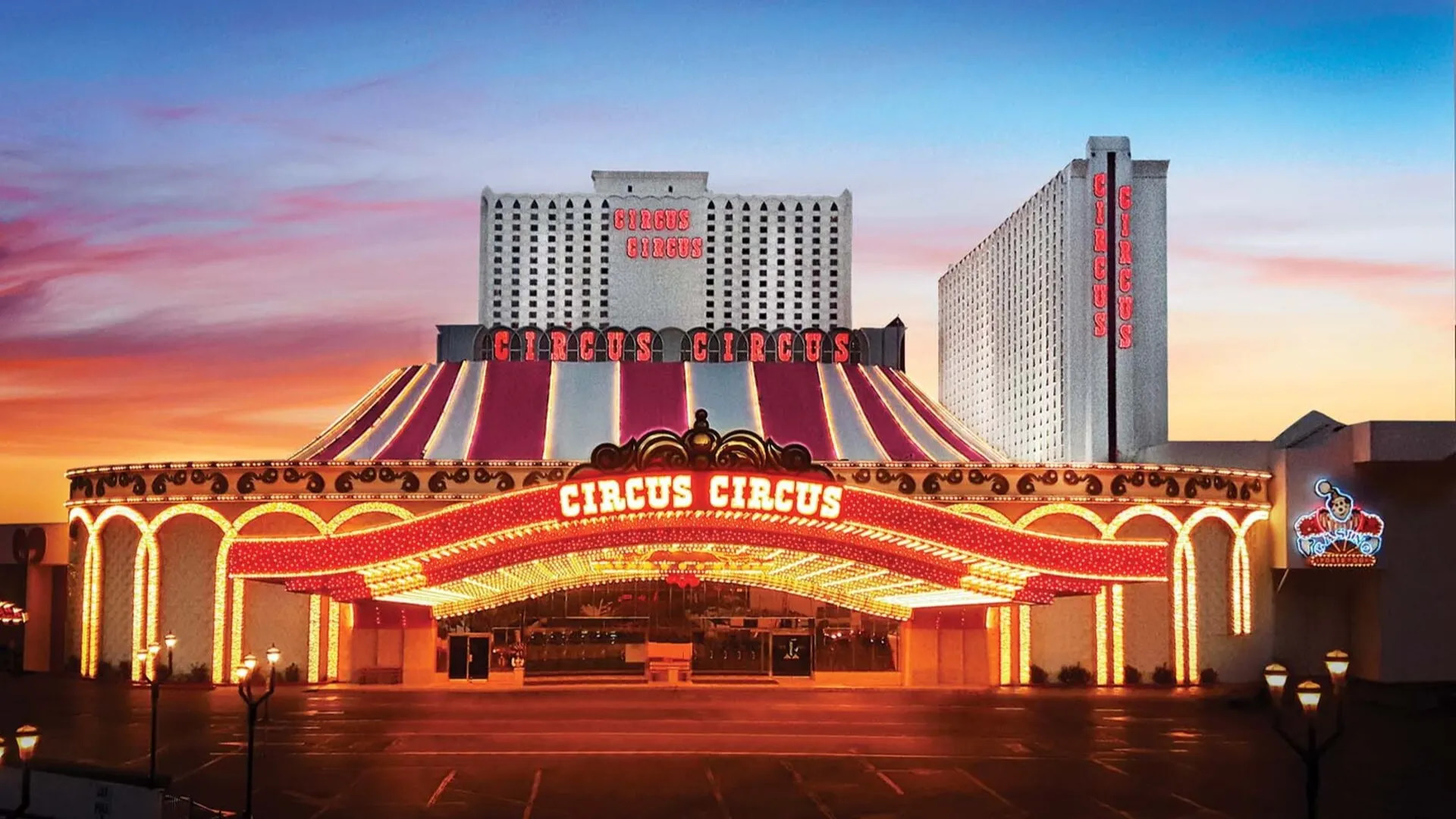 Circus Circus’s tent-shaped entrance roof and illuminated porte-cochere at dusk.