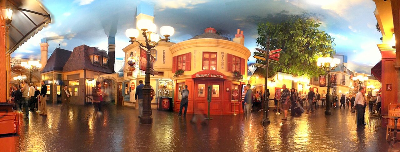 Artificial sky over cobbled indoor streets and shopfronts.