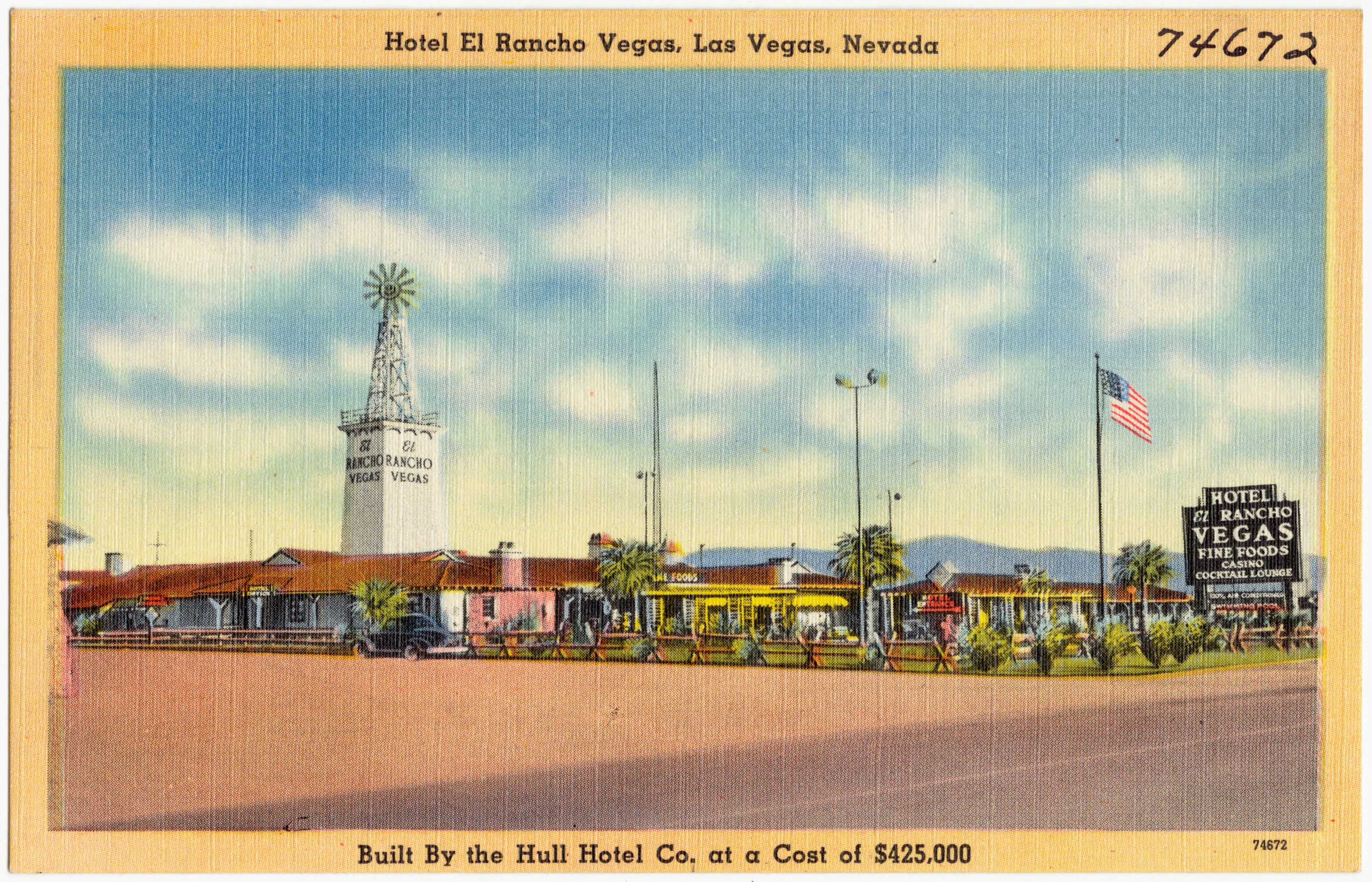 Color postcard view of El Rancho Vegas, with low buildings, palm trees and a central windmill tower.