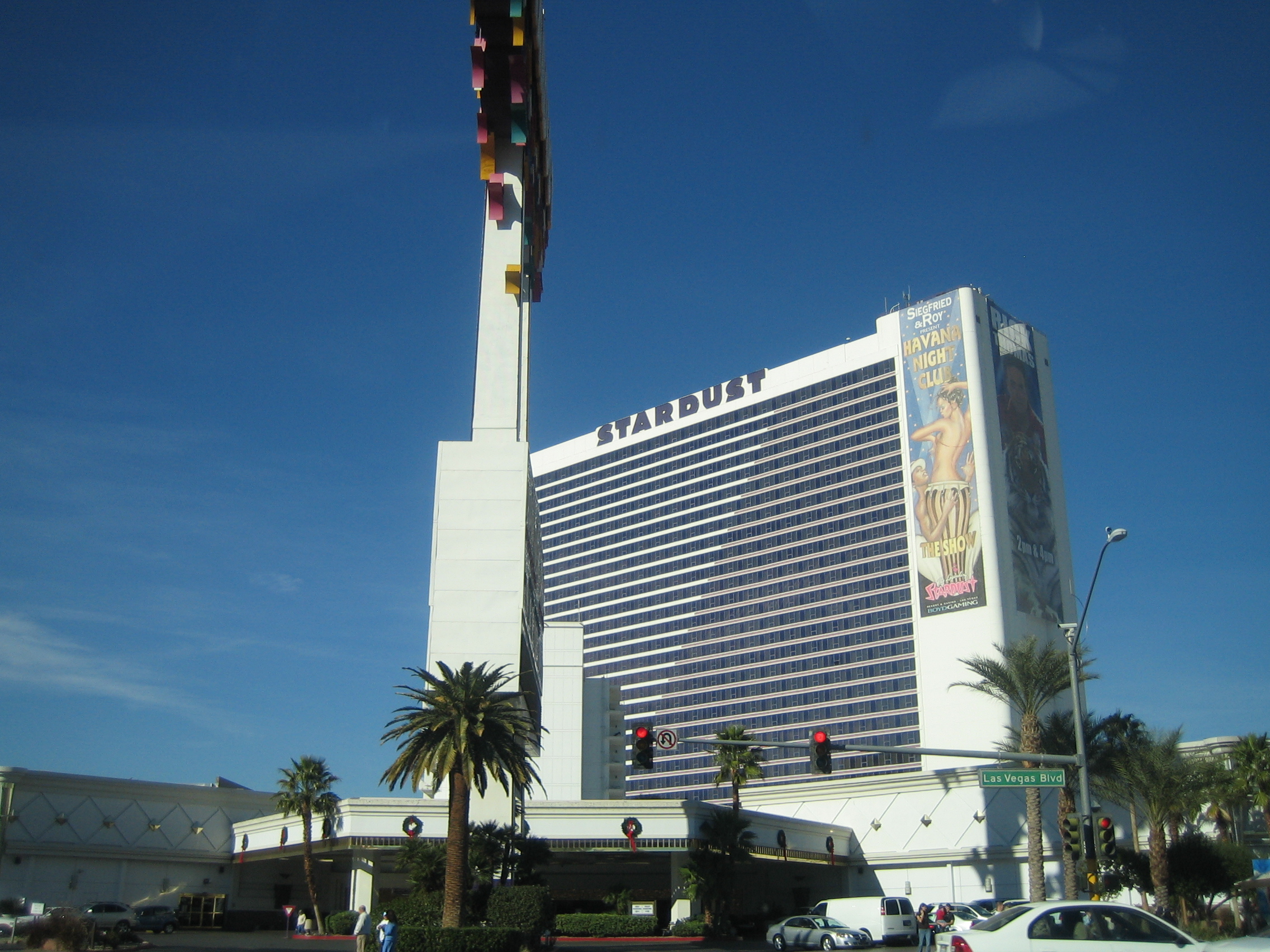 Stardust’s hotel tower and roadside-sign support, with historic Havana Night Club advertising and Strip traffic.