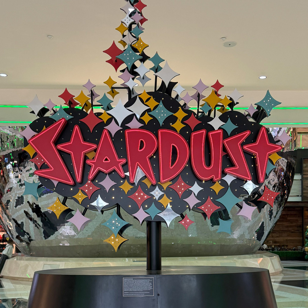 A Stardust sign display with colourful starbursts and a reflective globe behind it.