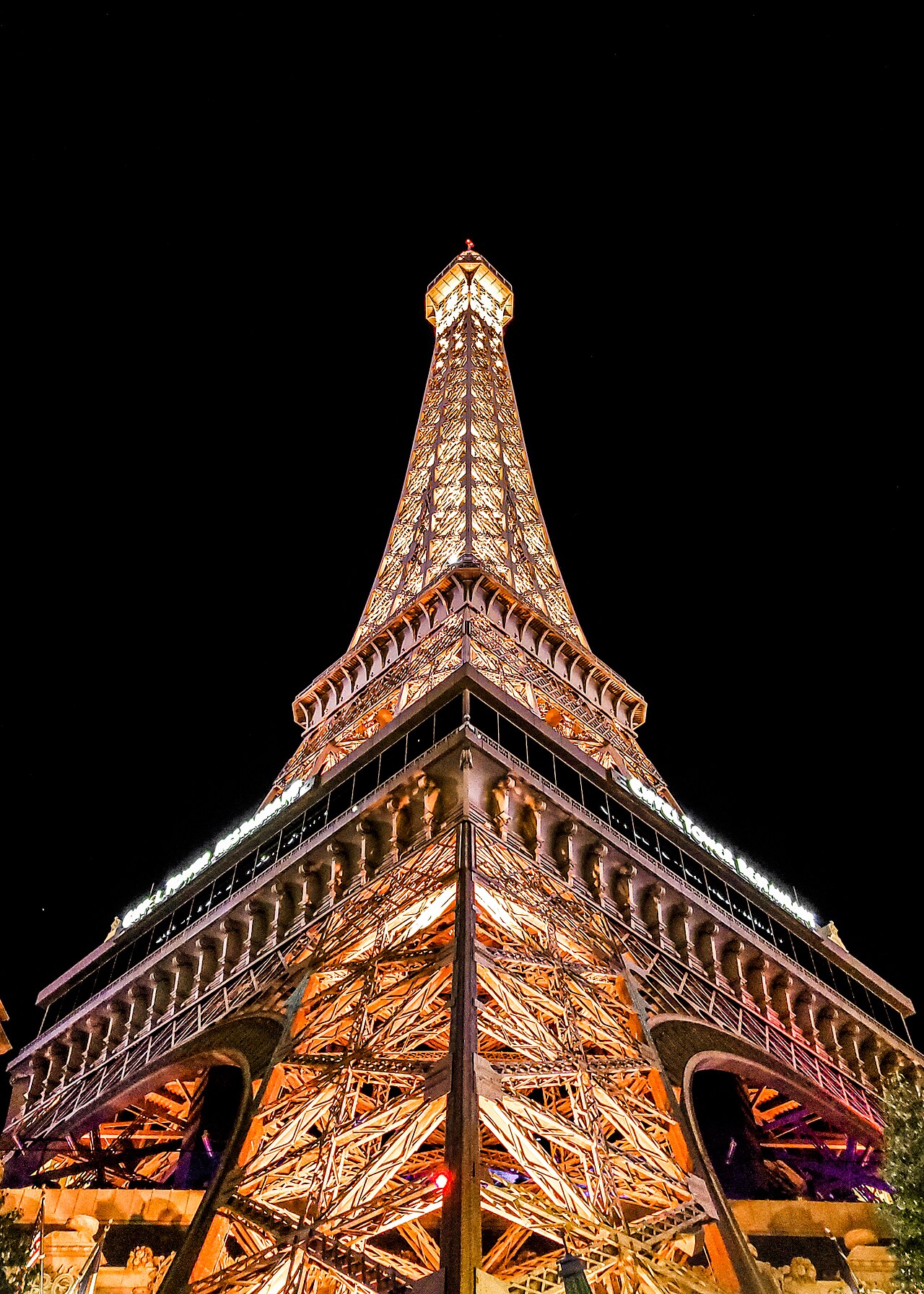 Low angle of the steel Eiffel Tower replica with its restaurant level and four legs.
