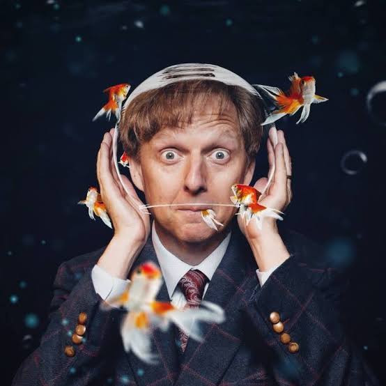 A promotional portrait of a performer with goldfish.