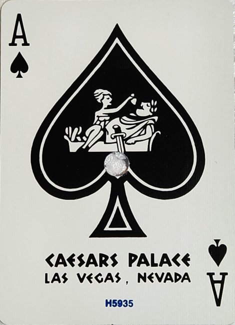 Caesars Palace ace of spades with a circular cancellation hole through the reclining Roman figure.