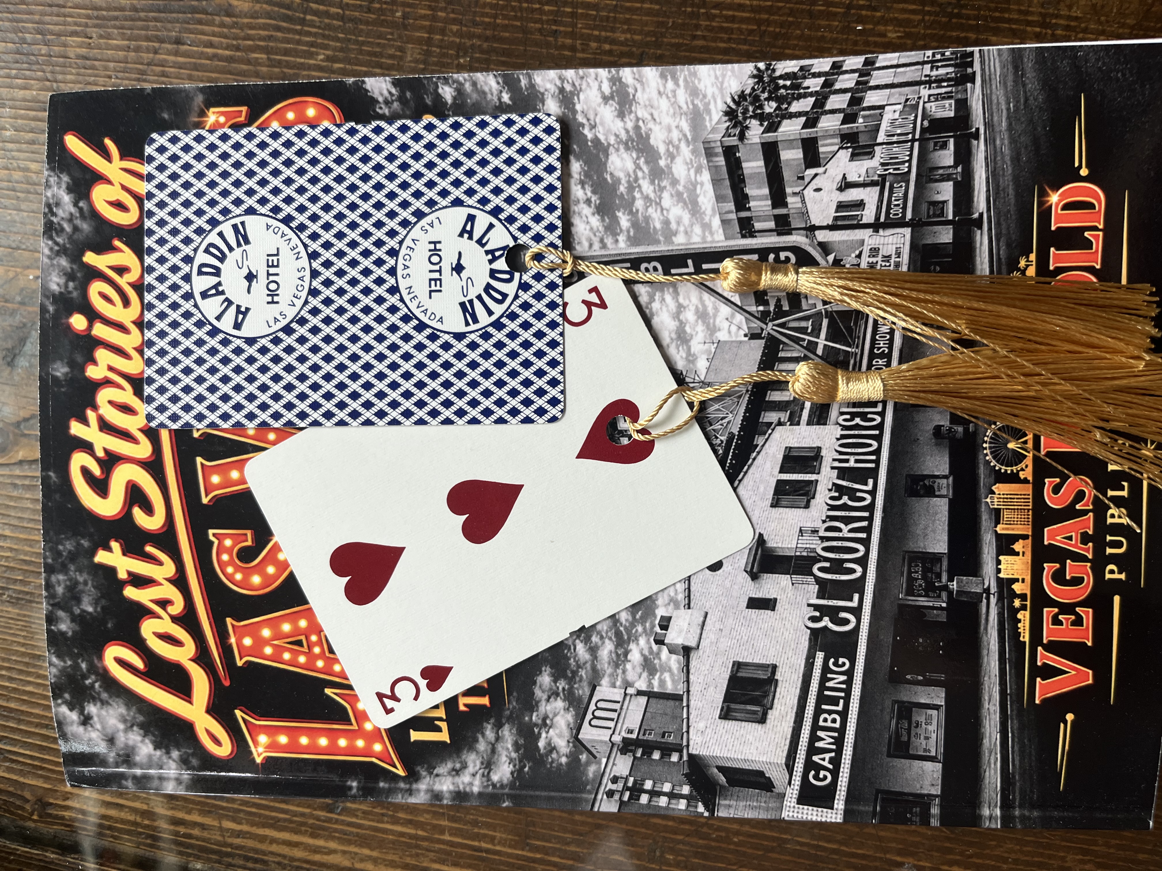 Three of hearts and Aladdin playing-card back repurposed as bookmarks with gold-coloured tassels.