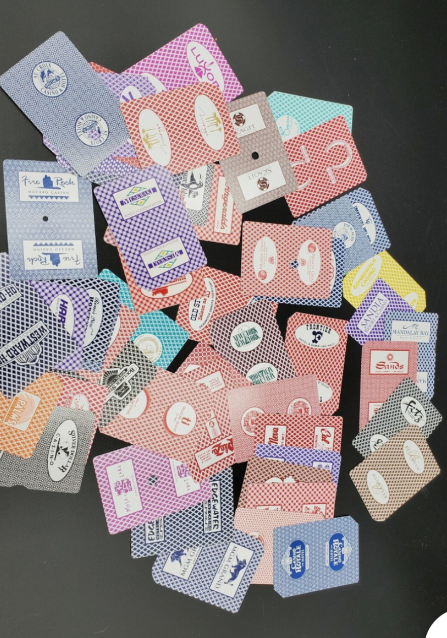 Overlapping casino playing-card backs in different colours and patterns, including Luxor, Harrah’s and MGM Grand.