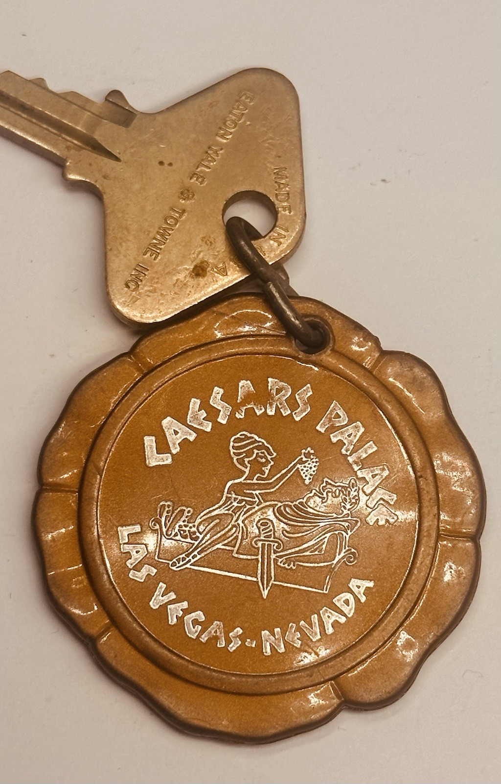 Caesars Palace key and scalloped bronze-coloured fob with a Roman figure.