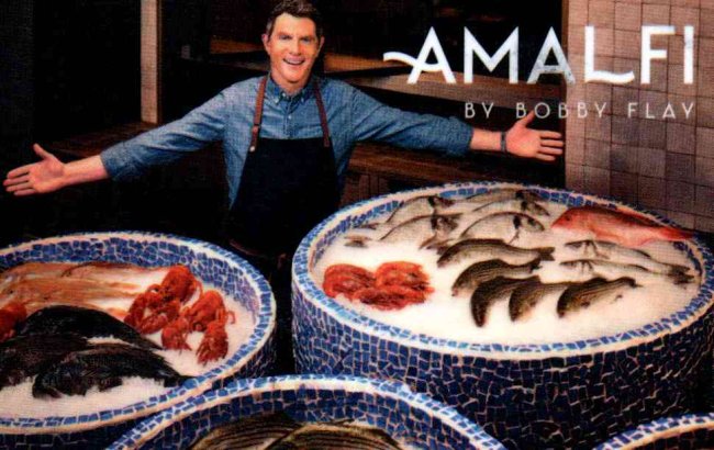 Keycard advertising Amalfi by Bobby Flay, with the chef standing behind displays of seafood.