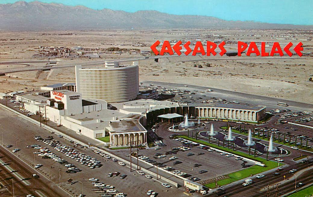 An aerial postcard view of Caesars Palace with its curved hotel tower and fountain approach.