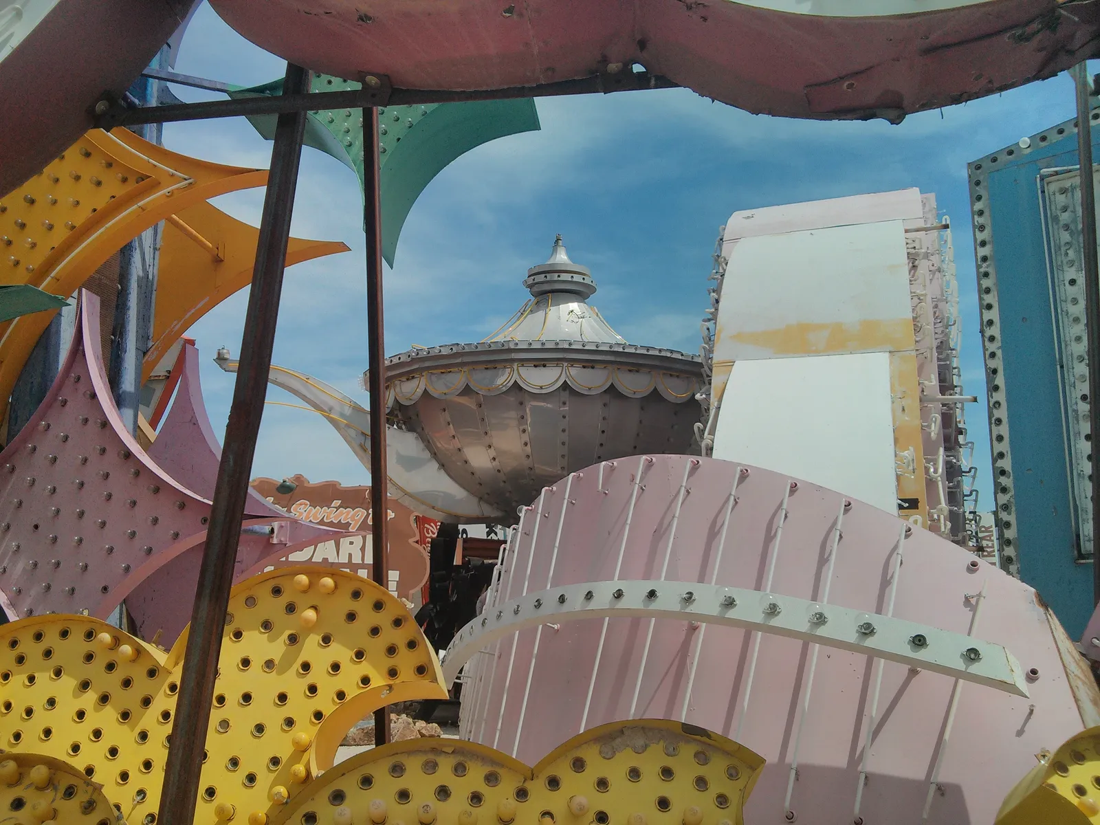 A large silver Aladdin lamp surrounded and partly obscured by other salvaged neon sign pieces at the Neon Museum in 2013.