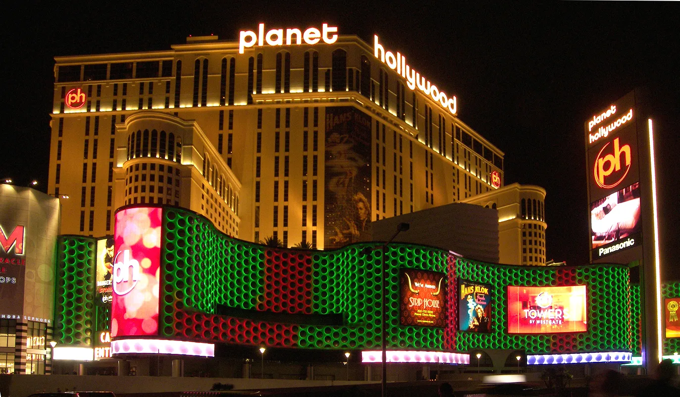 Planet Hollywood’s illuminated hotel towers, bright casino frontage and round ph sign at night in 2007.