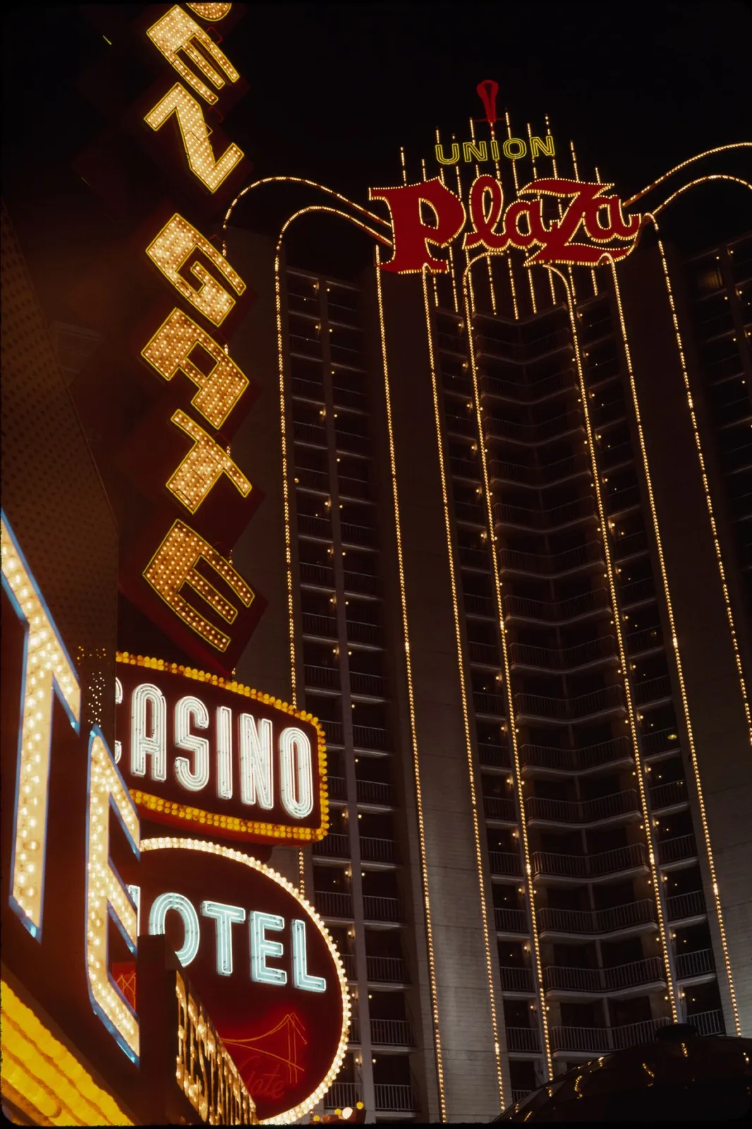 Union Plaza’s illuminated roof sign and hotel tower behind the Golden Gate’s neon casino sign.