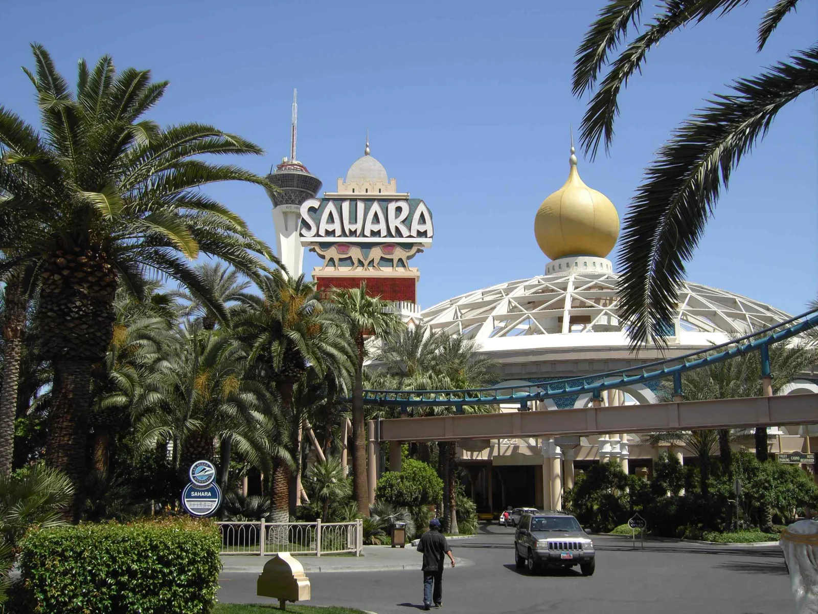 Sahara’s sign, gold-domed canopy and palms in 2006, with roller-coaster track in front and the separate Stratosphere tower behind.