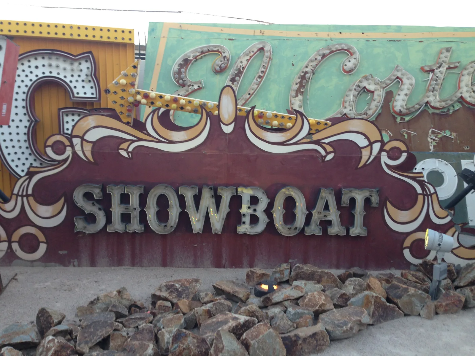 A red-and-cream ornamental panel spelling SHOWBOAT among preserved signs at the Neon Boneyard, with an El Cortez sign behind it.