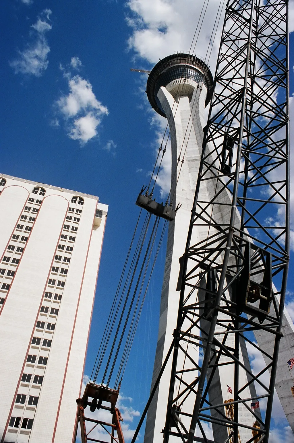 An earlier Vegas World hotel tower at left beside the Stratosphere observation tower under construction, with a crane in front.
